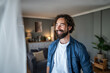 © Migma_Agency - Confident man smiling looking away in living room