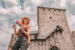 © EdNurg - Happy tourist holding Serbian flag visiting the medieval fortress on top of a hill near Vrsac in Serbia