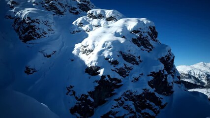 Wall Mural - deep shadows and bright highlights on a snow-covered rock formation, dramatic side light, slow push 