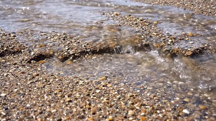Wall Mural - Close-up of rapid rainwater runoff flowing over an unpaved, textured ground, creating small rivulets and erosion patterns under bright light stream, erosion patterns, elemental