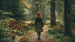 © Puthorn - A red haired woman walks along a leaf strewn forest path, amidst tall trees and lush foliage, on an overcast autumn day in the misty woods outside.