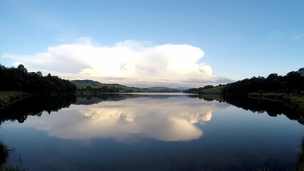 Wall Mural - Serene timelapse of clouds gracefully reflecting on the perfectly still surface of a pristine lake meditation, mirror, reflection