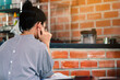 © JinnaritT - Young asian woman looking reading book and taking notes in cafe. Serious female student is sitting reading textbook preparing for exams. Female student stressed out and focused studying for exam.