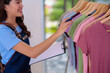 © snowing12 - Asian woman small business owner checking clothing inventory managing apparel stock for online retail boutique shop sales product organization efficient management happy entrepreneur