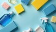© miss irine - Cleaning supplies arranged on blue background. Sponges, bottles, sprays in various colors. Cleaning tools organized for household chores. Top view of hygiene products. Blue, yellow cleaning
