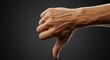 © hd - A Human Hand Giving a Thumbs Down Gesture Against a Dark Background Represents Disapproval or