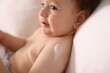 © New Africa - Cute little baby with cream on his body lying in bed, closeup