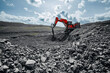 © Parilov - Heavy excavator machinery operating under cloudy sky, Open pit mine process, industry landscape.