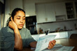 © Marko Geber - Woman reviewing bills at home