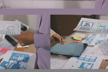 Close up ux developer and ui designer brainstorming about mobile app interface wireframe design on table with customer breif and color code at modern office.Creative digital development agency.