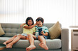 © ADDICTIVE STOCK - Siblings enjoy playful moment on a cozy couch