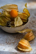 © ADDICTIVE STOCK - Cape gooseberry in rustic bowl with dried leaves