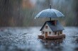 © Nure - Tiny house sheltered from downpour under umbrella offering security and peace of mind for home owners