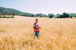 © ADDICTIVE STOCK - Field worker in a golden barley field under clear sky