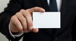 © FAWF STUDIO - A male hand in the foreground holding a blank white business card, with a dark suit blurred in the background.