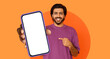 © Prostock-studio - A young man smiles and points at a blank smartphone screen he is holding. The setting features a bright orange background, creating a lively atmosphere.