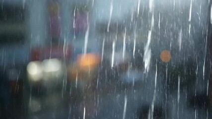 Wall Mural - a shallow depth of field close-up of heavy rain obscuring an abstract, urban background, emphasizing