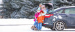 © Pixel-Shot - Parents and their little children sitting in car trunk on snowy winter day