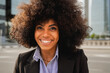 © Vane Nunes - Afro latina business woman smile outside office buildings - Professional corporate portrait concept