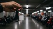 © Azwardi - Close-up of a hand holding a modern smart key fob against a blurred background of a bustling motorcycle parking garage, symbolizing urban security and asset tracking technology