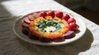 © Iris - Colorful vegetable and fruit arrangement on a white plate in a rainbow pattern
