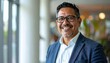 © Hyejin Kang - Portrait of successful 40s businessman in glasses Asian looking at camera and smiling, man working inside modern office building.