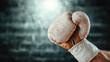 © siraphol - Close up of boxing glove with worn texture, showcasing strength and determination