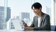 © Yka - ジャケット姿でPCとスマホを使うビジネスマン