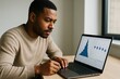 © Pixels Hunter - Focused man analyzing data on laptop with stylus in hand, displaying blue statistical graphs in modern office with light background setup. Ai generative