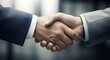 © MdFoysalAhmed - A close up of two business people shaking hands wearing suits in a professional setting indoors