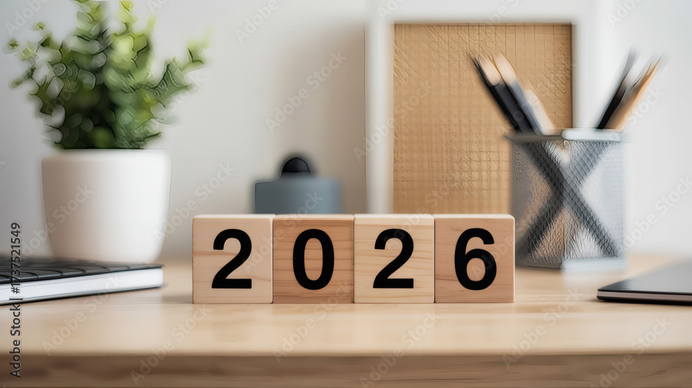 Wooden blocks forming 2026 year on office desk with plant and ...
