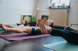 © qunica.com - Participants engage in a fitness class, practicing Pilates together on yoga mats in a well-lit indoor room, focusing on strength, flexibility, and wellness.