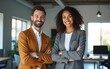 © Daniel - Portrait of two caucasian confident successful company employees, business colleagues, a man and a woman, stand near the desktop in a modern office, look at the camera, smile friendly. High quality
