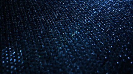 Macro shot of blue plastic woven mesh with reflective highlights and textured pattern.
