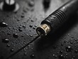 © dewpra - Macro shot of a black audio cable with water droplets on a dark surface
