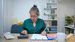 © Wosunan - On a holiday, an elderly woman record of household and personal income and expenses