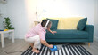 © Wosunan - On a holiday, an elderly woman is relaxing at home and vacuuming the living room