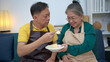 © Wosunan - On a holiday, an elderly couple tests out handmade desserts at home.