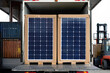 © VITALII - Palletized photovoltaic solar panels being unloaded from a truck at an industrial shipping dock.