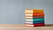 © pinporn manosri - Stacked Colorful Books on a Wooden Table with a Soft Blurred Background Ideal for Education, Learning, or Reading Themes in Modern Design Context