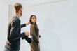 © qunica.com - A photographer interacts with a female model during a photo shoot in a bright studio, using a camera to capture moments. The image emphasizes communication and expression during a photography session.
