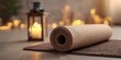 © Mr. Mike - A rolled-up yoga mat on a brown mat with a wooden floor, a wooden floor lamp with a lit candle, and a blurred background of fairy lights.