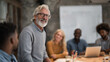 © tiagozr - Senior businessman leading meeting with diverse team.
