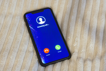 Smartphone displaying an incoming call screen with Decline and Accept buttons. Concept of communication and social networking.