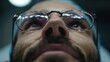 © shobakhul - Portrait of a person gazing upwards, viewed from below, showcasing their glasses, with reflection details visible and wearing a surgical cap.