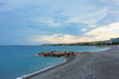 Beautiful view of wavy sea, city and pebbles on beach