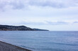 Beautiful view of wavy sea, city and pebbles on beach