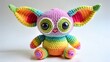 © Shibu - Rainbow crocheted monster toy isolated on white background is sitting pretty