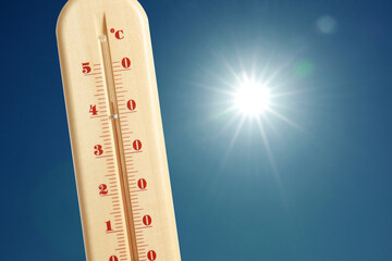 Wall Mural - thermometer showing high temperature against sky with bright sun. extremely hot weather