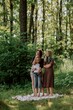 © looking2thesky - A young mother joyfully plays with her daughter and son in nature, sharing authentic family moments of laughter and connection. Pure love and outdoor happiness